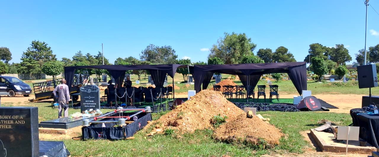Graveside marquee with elegant black draping prepared for a service